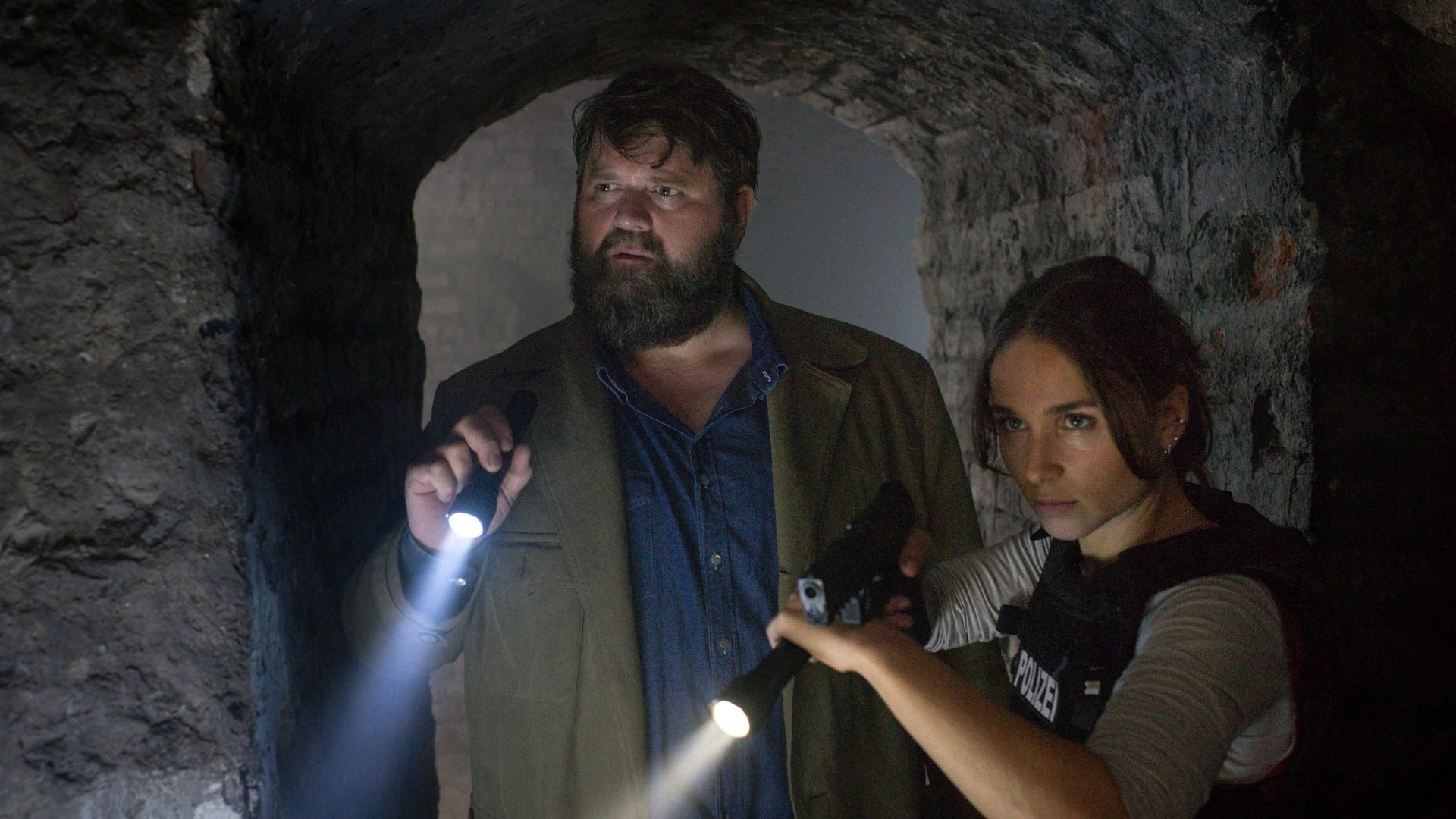 « Behringer und die Toten: Ein Bamberg-Krimi - Antoniusfeuer » : le commissaire Behringer (Antoine Monot Jr.) et la jeune commissaire Ela Jenning (Cosima Henman) font une découverte dans les galeries souterraines.